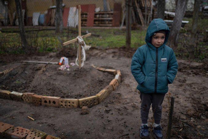 La storia dietro la foto del bambino di 6 anni che piange sua madre sulla sua tomba a Botsja